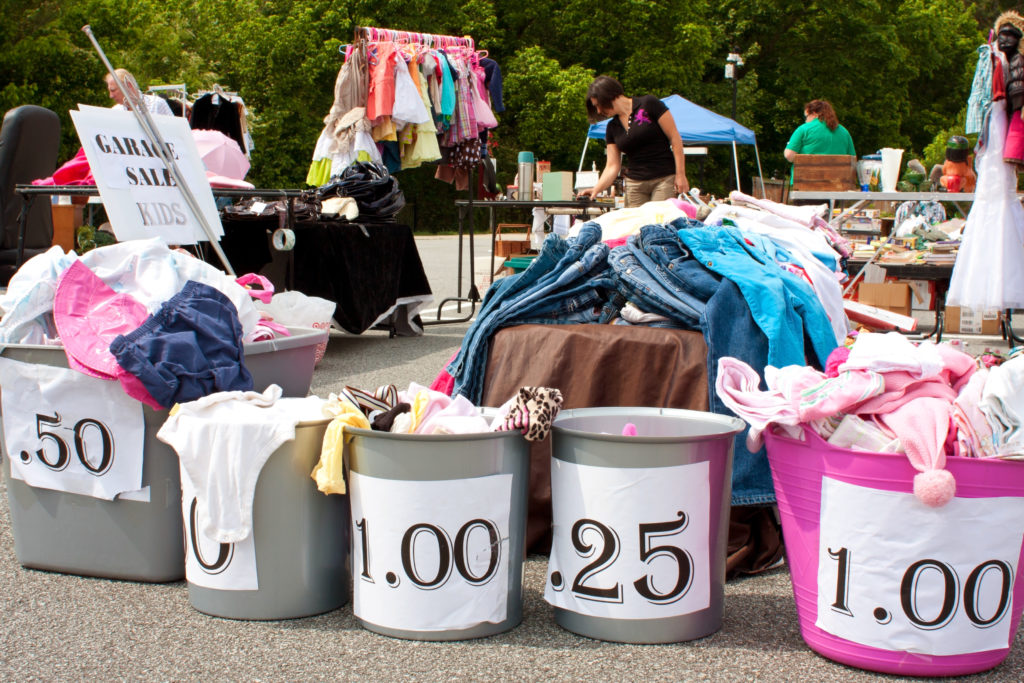 "Lilburn, GA, USA - April 21, 2012: Containers labeled with prices hold merchandise being sold in a parking lot at the Lilburn citywide garage sale"