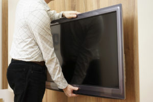 A man packing a flat screen tv in Perth